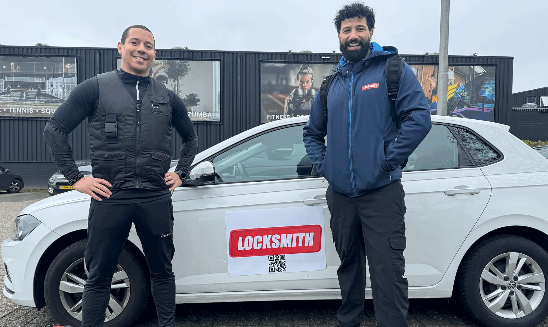 Twee mannen naast auto met slotenmaker reclame.