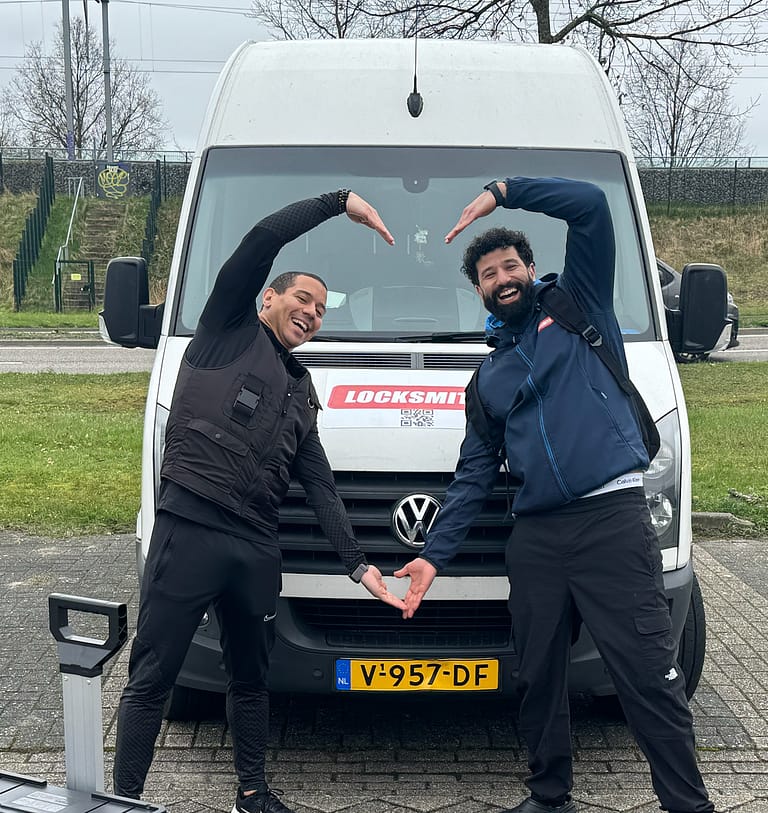 Twee mannen poseren vrolijk voor een slotenmakersbusje.